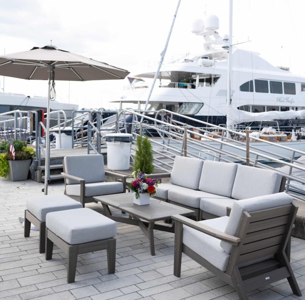 Outdoor seating with a moored yacht in background